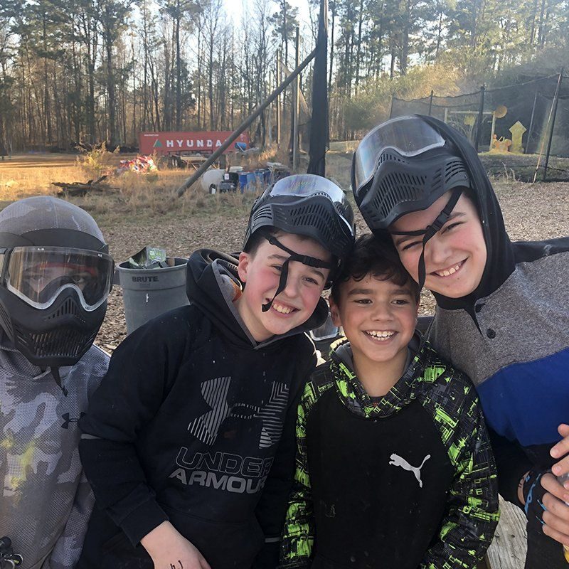 Friends celebrating a paintball birthday party
